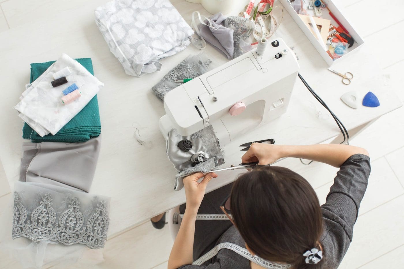 Tailor, fashion and seamstress concept - young female fashion designer in her showroom, top view