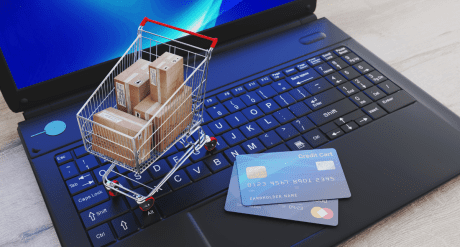 Laptop with credit cards and trolley - concept for e-commerce and non-EU imports