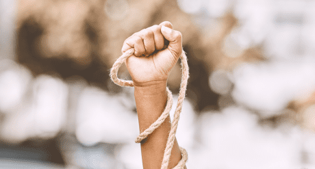 Hand holding a rope - concept for forced labor and modern slavery