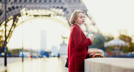 Woman wearing red coat at eiffel tower - concept for French Environmental Cost of Textiles